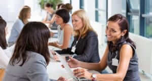 Business women communicating to other business woman with laptop