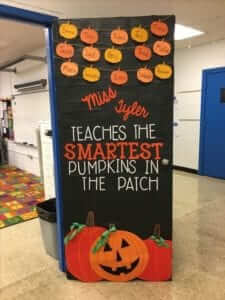 Classroom door that says "Miss Tyler teaches the smartest pumpkins in the patch". At the top are pumpkins with students' names. At the bottom are two pumpkins and a jack-o-lantern