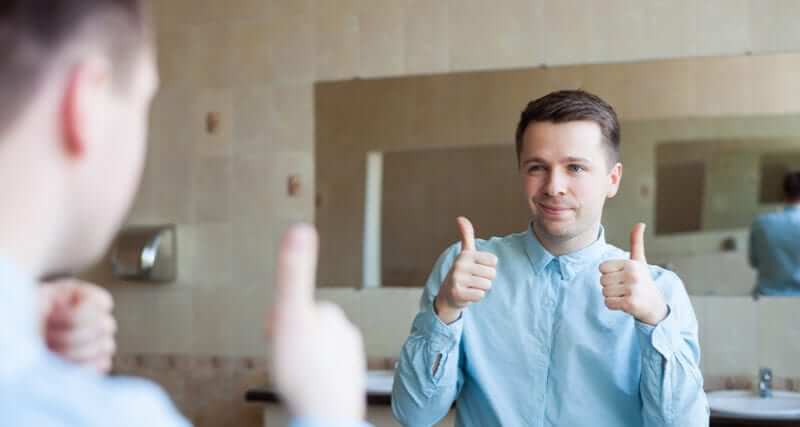 Male giving himself thumbs up in a bathroom mirror