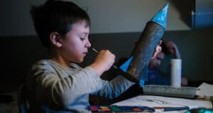 male child working on a space ship craft